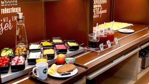 A buffet with various food options including fruits, cheeses, and juices. - B&B HOTEL Flensburg-City (Flensburg)