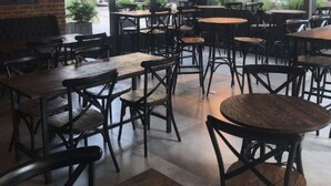 A restaurant interior with multiple tables and chairs, large windows, and a brick wall with a mural. - ibis styles Montevideo Biarritz Hotel (Montevideo)
