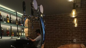 Un bar con mostrador de madera y una grifo.