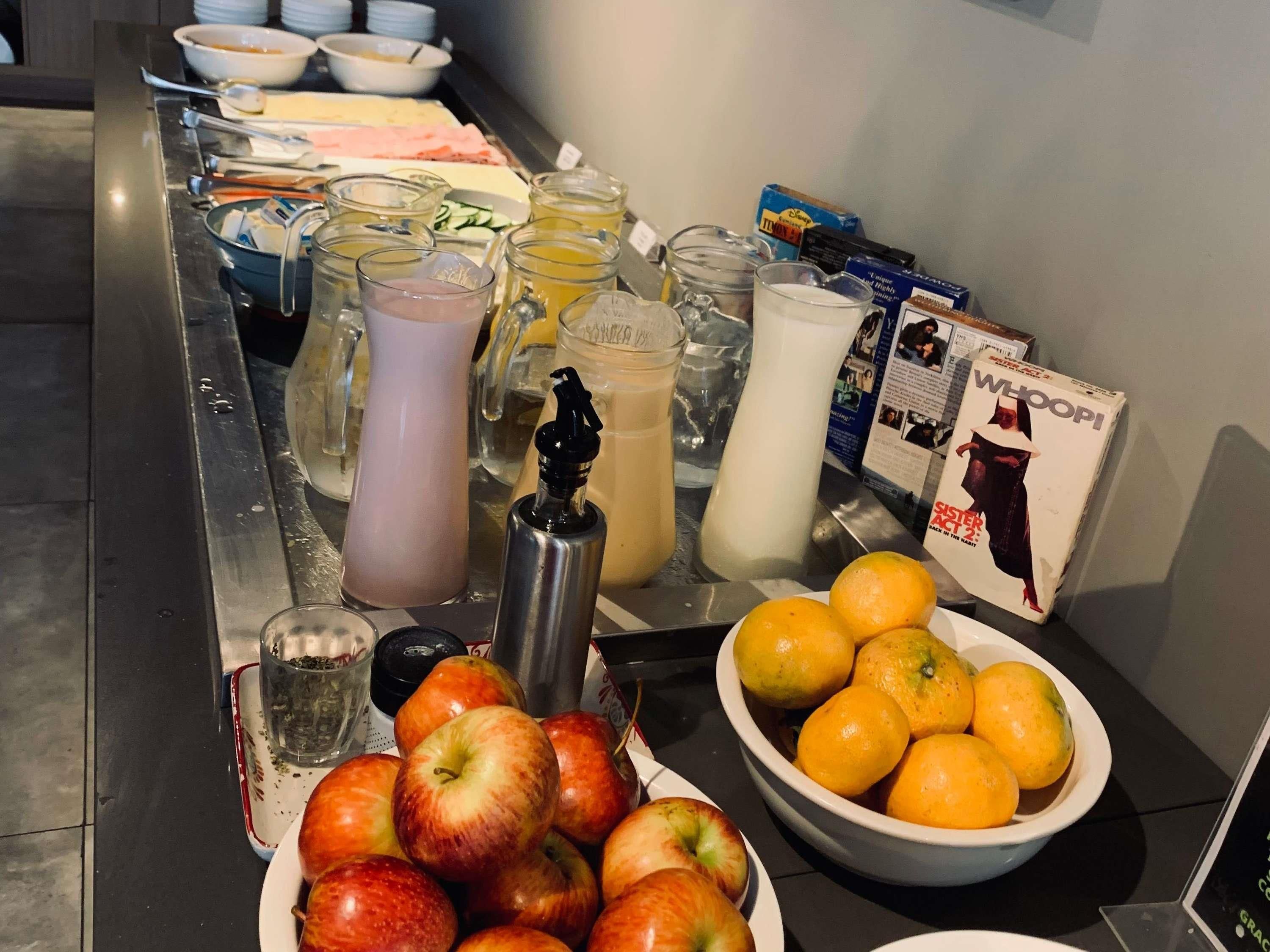 Une table de buffet proposant une variété de plats, de boissons et d’assaisonnements.