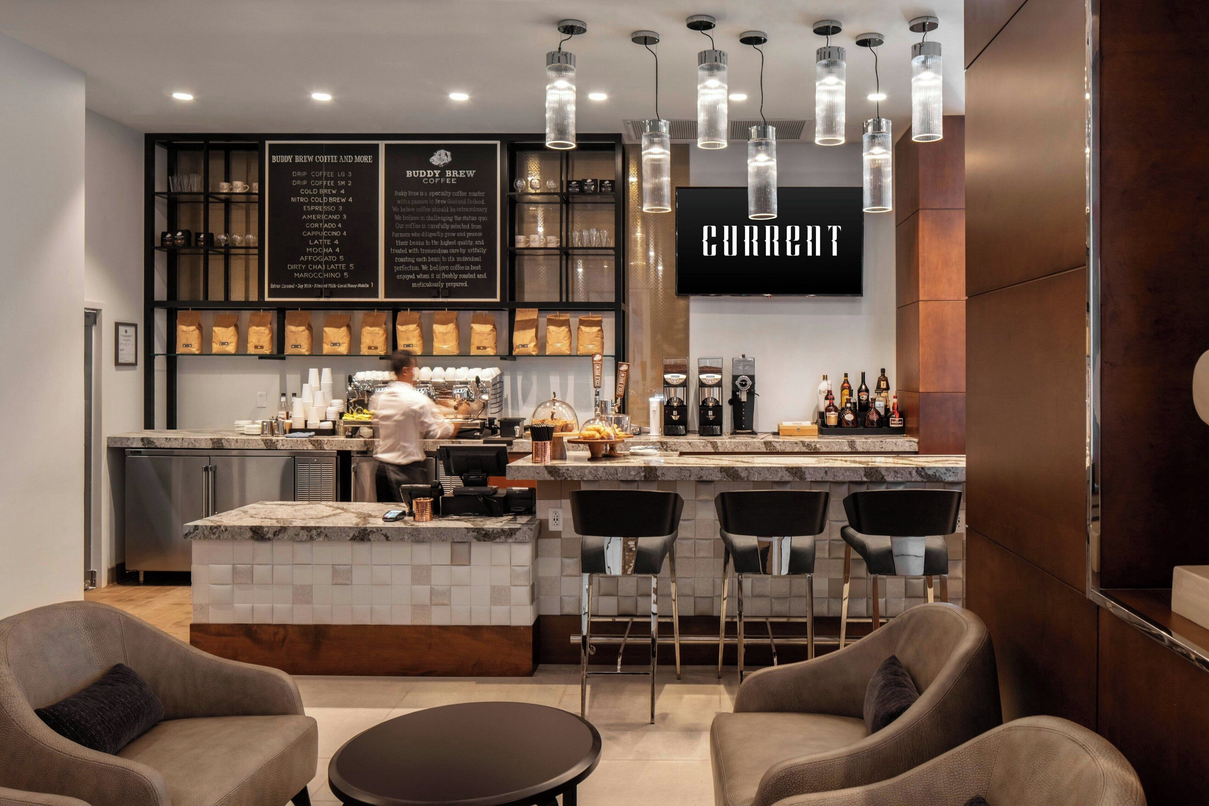 A modern bar area with a coffee menu, bar stools, and a counter.