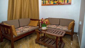 Un salon comprenant un canapé, une table basse et un tableau accroché au mur.