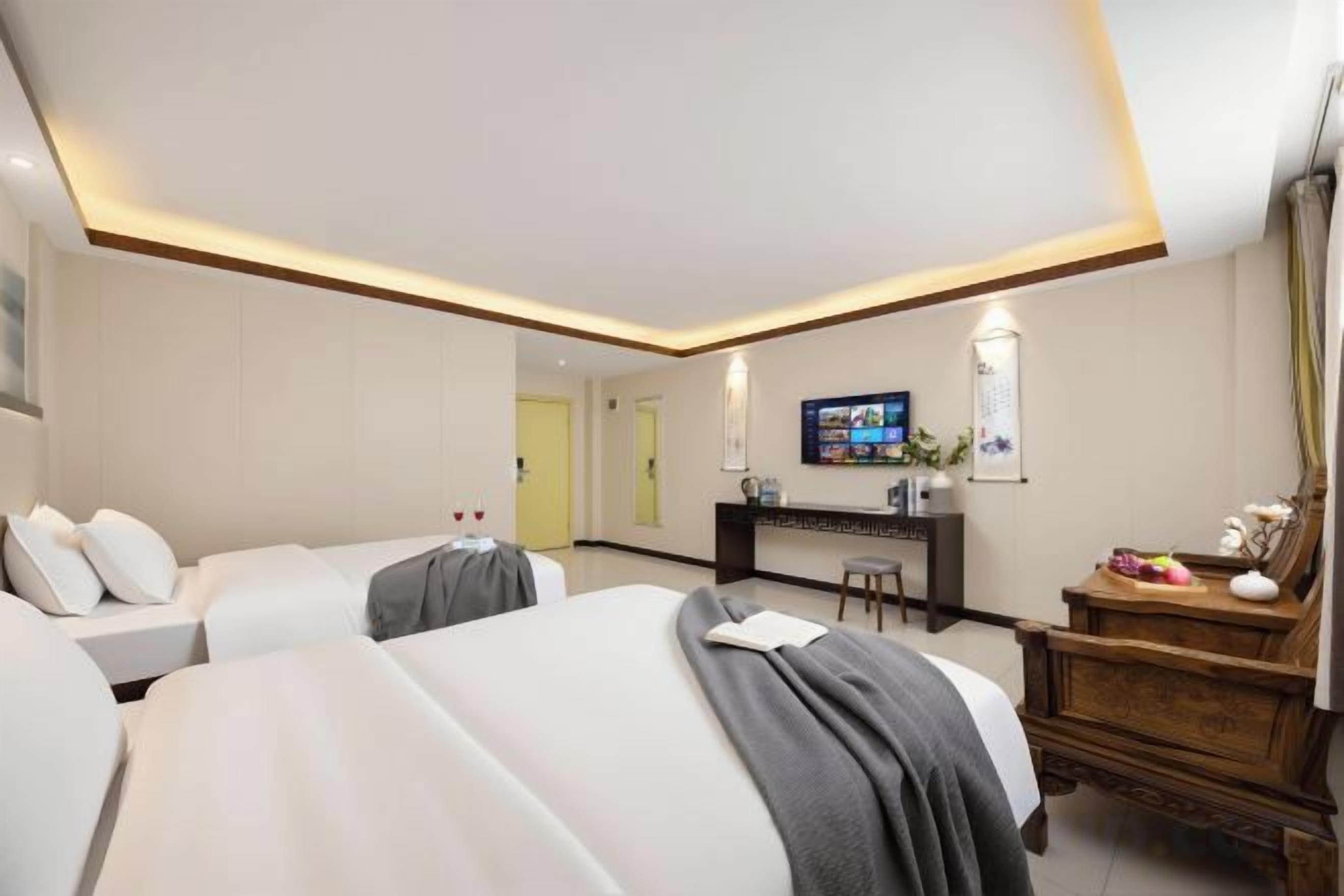 Une chambre d’hôtel avec deux lits, un bureau, une télévision et un miroir.