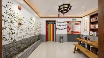 A reception area with a reception desk, a wall-mounted sign, a bookshelf, and a bench.