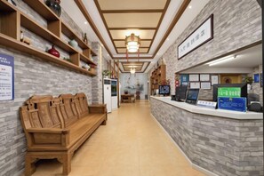 A reception area with a wooden bench, a reception desk, and a wall-mounted sign. - 8 Inn (Dongguan Dongkeng) (Dongguan)