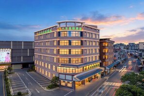 A multi-story hotel with a modern design, featuring a prominent entrance and a parking lot. - 8 Inn (Dongguan Dongkeng) (Dongguan)