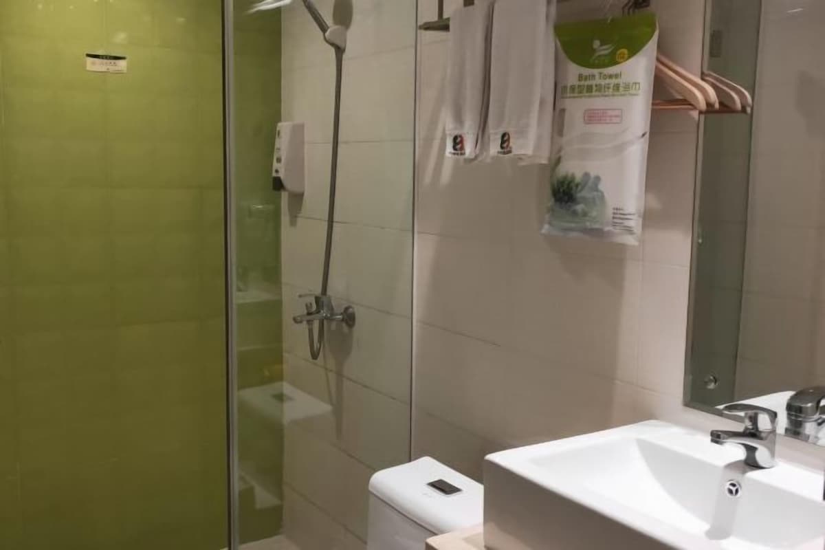A modern bathroom with a glass-enclosed shower, a white sink, and a mirror.