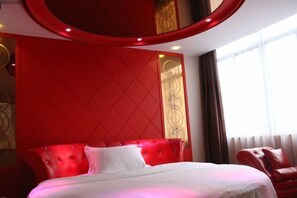 A hotel room with a red upholstered headboard, a white bedspread, and a red leather armchair. - 8 Inn (Dongguan Dongkeng) (Dongguan)