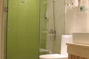 A bathroom with a glass-enclosed shower, a white toilet, and a sink with a beige countertop. - 8 Inn (Dongguan Dongkeng) (Dongguan)