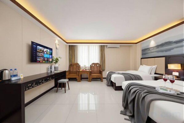Une chambre d’hôtel avec un lit, un bureau, une télévision et une fenêtre avec des rideaux.