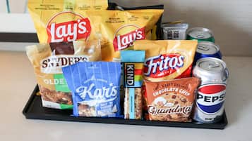 A tray with snacks and drinks including Lay's chips, Pepsi, and other packaged foods.