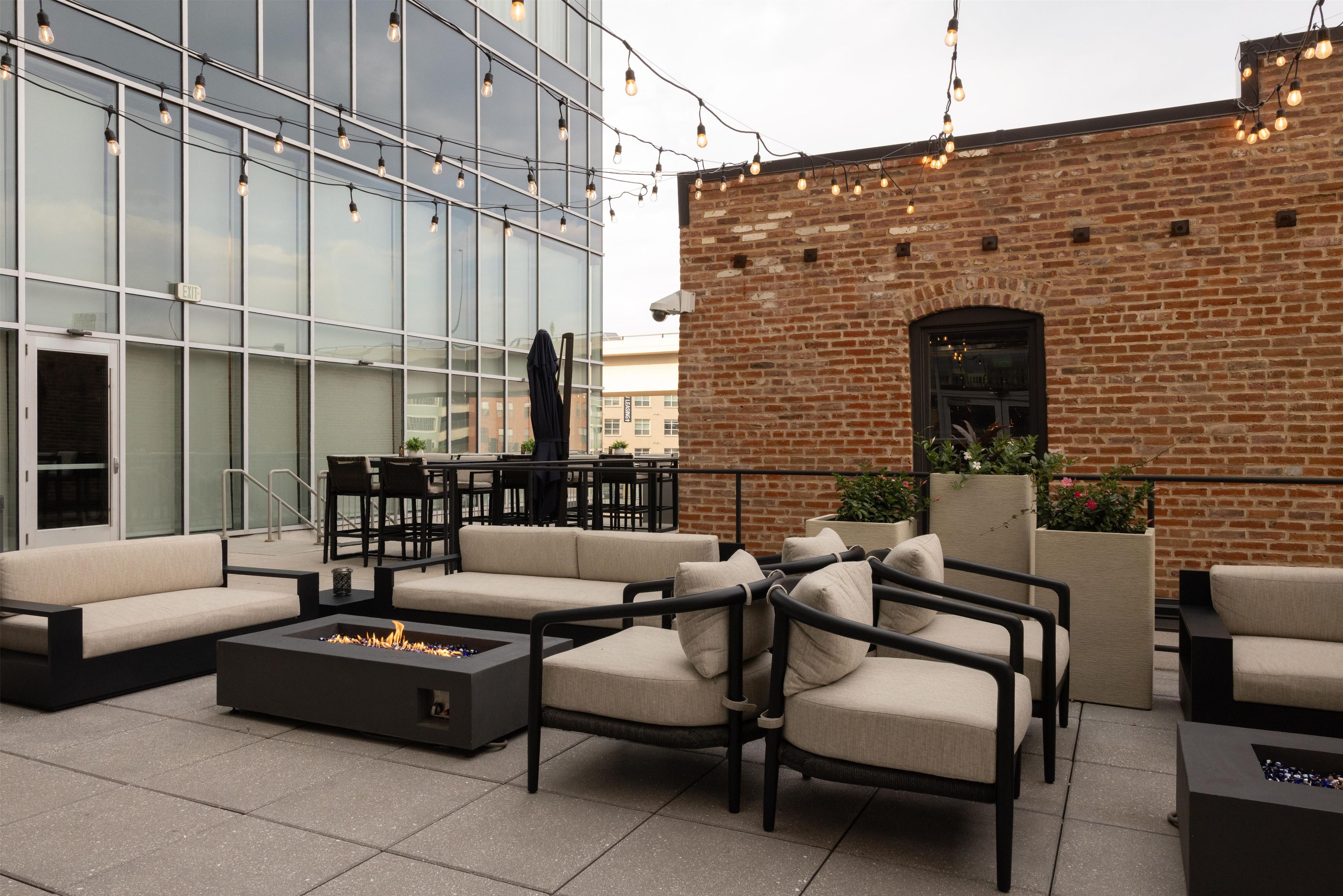 An outdoor seating area with sofas, chairs, and a fire pit.