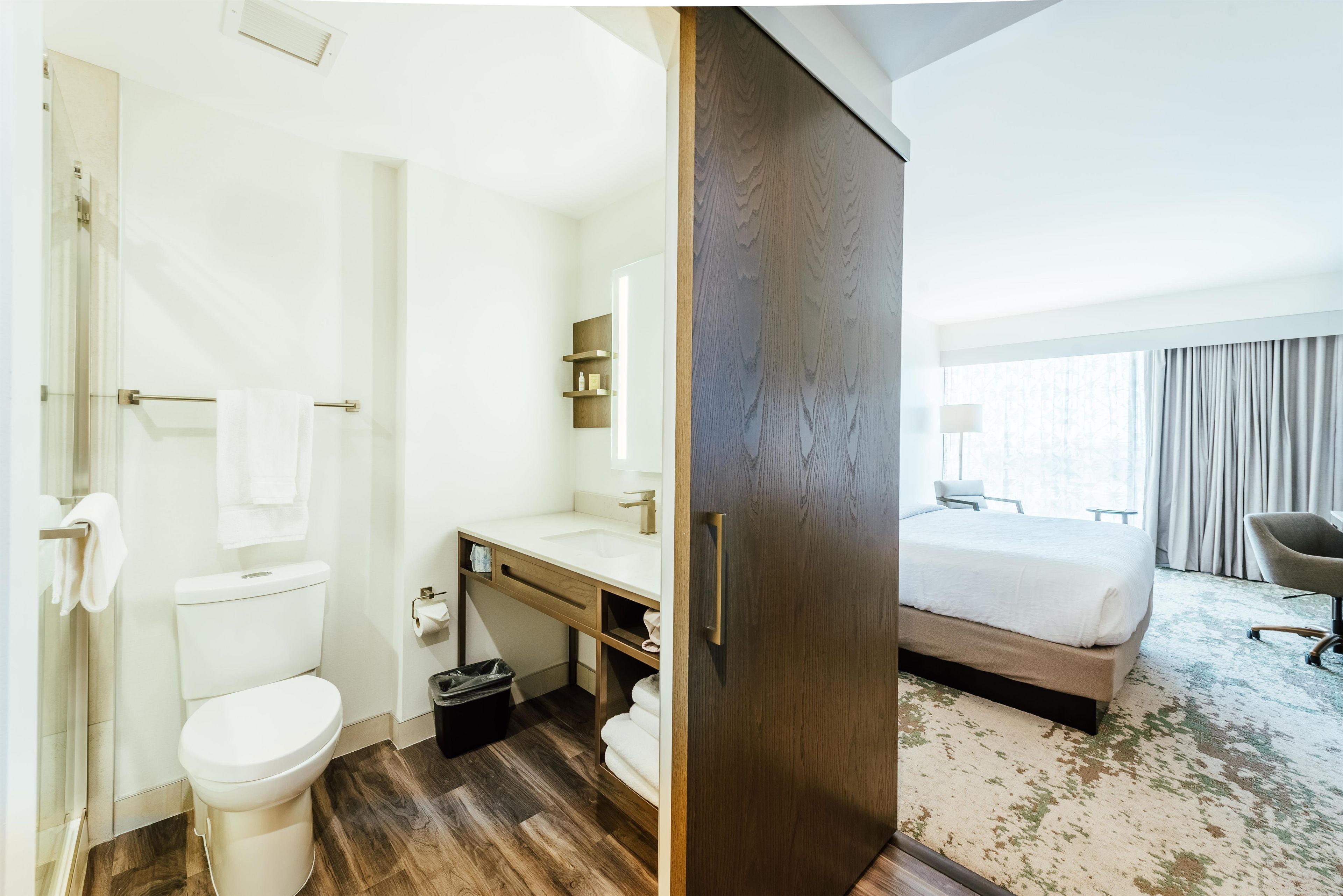 A hotel bathroom with a toilet, sink, and shower.
