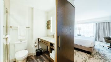 A hotel bathroom with a toilet, sink, and shower.
