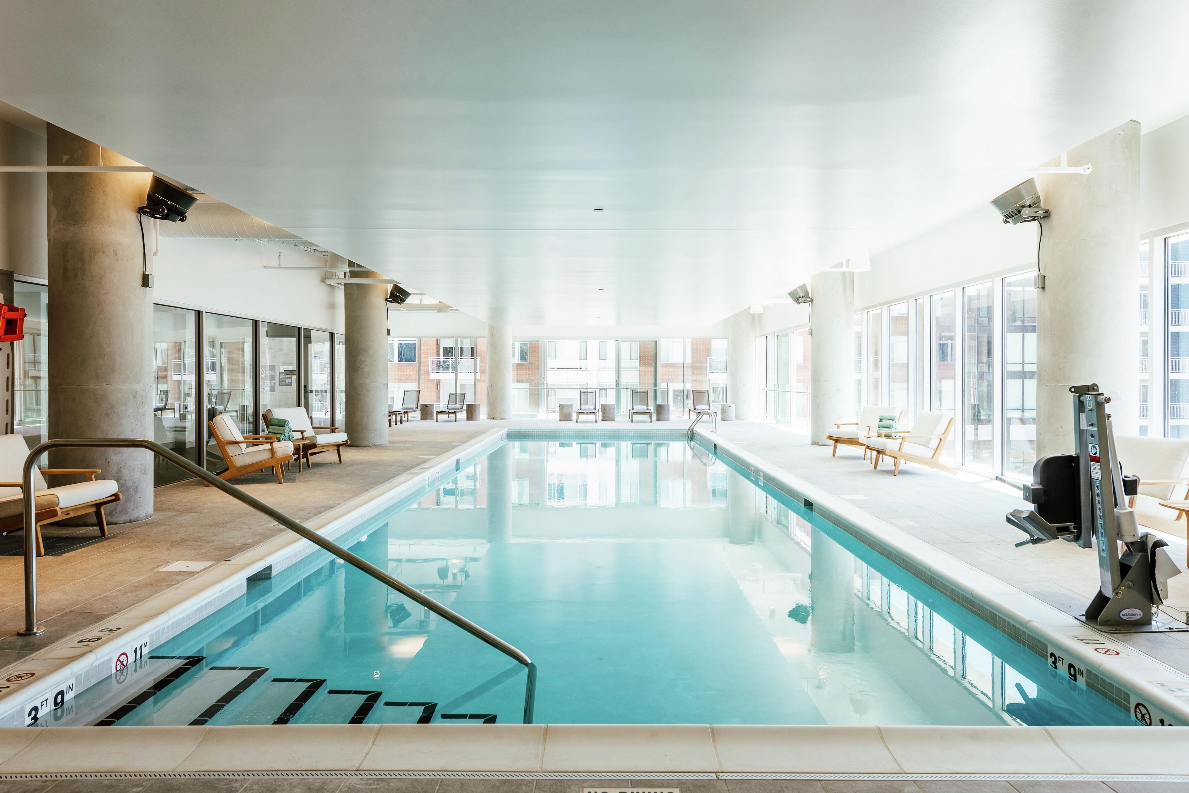 Una piscina interior amb gandules i vistes a l'exterior.