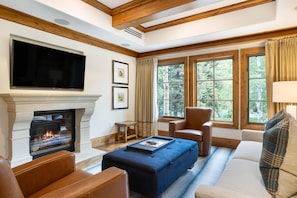 A living room with a fireplace, leather furniture, and large windows. - Willows 301 | Luxury 2BR Vail Village (Vail)
