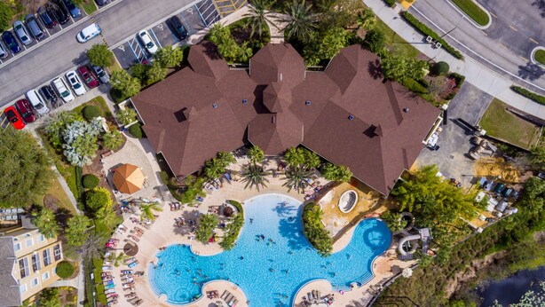 Vista aerea di un resort con una grande piscina, diverse aree coperte e un parcheggio.