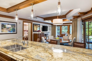 A kitchen with granite countertops, a built-in sink, and pendant lighting. - Willows 101 | Luxury 2BR Vail Village (Vail)
