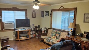 A living room with a television, sofa, and wooden flooring. - Tawakoni, lake front House /jacuzzi/fire pit. (Wills Point)