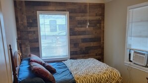 A bedroom with a bed, wooden floor, a ceiling fan, and a window with blinds. - Tawakoni, lake front House /jacuzzi/fire pit. (Wills Point)