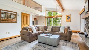 A modern living room with a sectional sofa, a coffee table, and a fireplace. - Riva Ridge 735 | 4BR Vail Village (Vail)