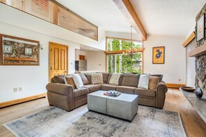 Ein modernes Wohnzimmer mit einem Ecksofa, einem Couchtisch und einem Kamin.