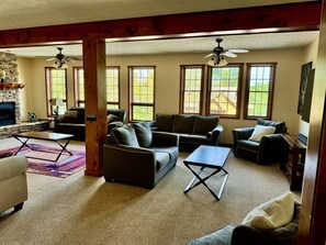 A spacious living room with a fireplace, multiple seating areas, and large windows. - Hawthorne Lodge - Walk to Slopes, Air Conditioning (Davis)