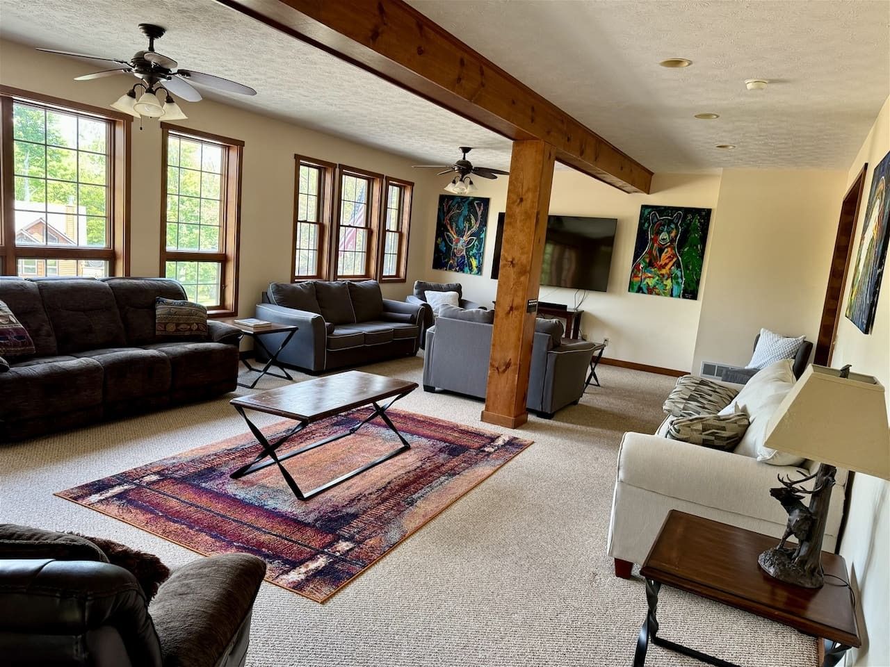 A spacious living room with a large window, a ceiling fan, and a fireplace.