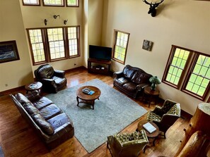 A spacious living room with leather sofas, a coffee table, and a television. - Hawthorne Lodge - Walk to Slopes, Air Conditioning (Davis)