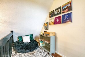 Een slaapkamer met een bed, een boekenkast en decoratie aan de muur.