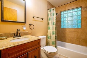 Une salle de bain avec un lavabo, des toilettes et une baignoire.