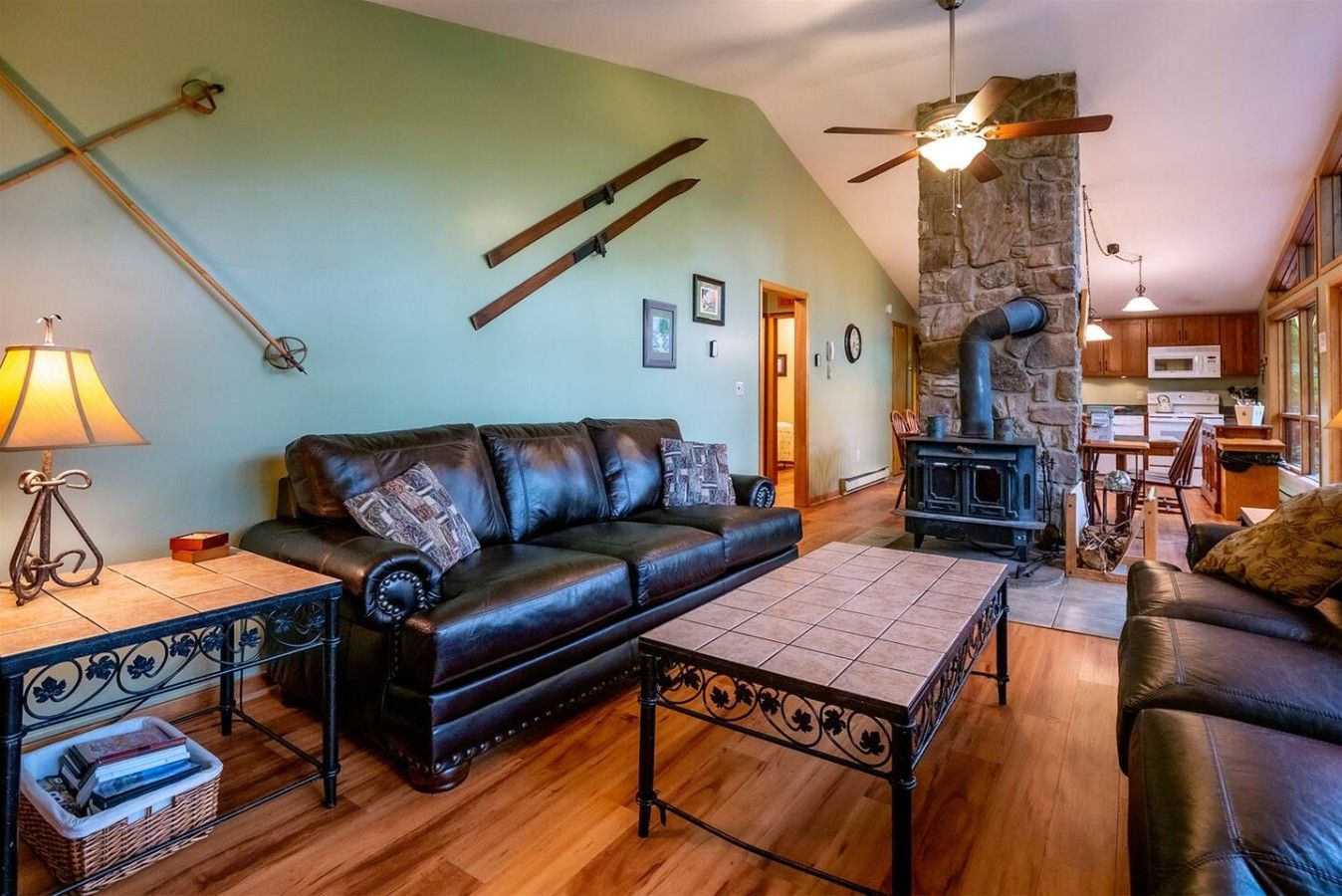 A cozy living room with a fireplace, a sofa, and a dining area with wooden cabinets.