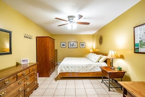 A bedroom with a bed, dresser, nightstand, lamp, ceiling fan, and wall-mounted pictures. - Our Greyt Escape - Lake Access and Hot Tub! (Davis)