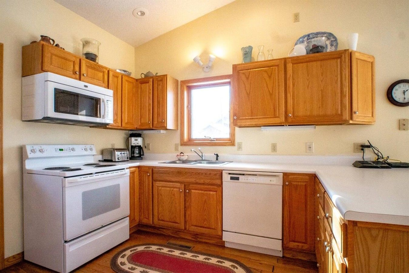 A kitchen with wooden cabinets, a microwave, stove, and dishwasher.