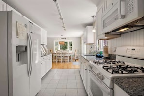 Enjoy cooking in this well-equipped kitchen with a central island, stainless steel appliances, and a view of the outdoors.