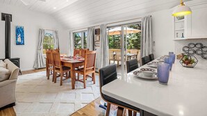 Une cuisine moderne avec un coin repas, des meubles en bois et une vue sur l’extérieur.