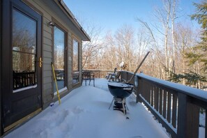 A covered deck with a barbecue grill, outdoor seating, and a snow-covered ground. - Bear Run - Dolly Sods & Lake Access, Hot Tub (Davis)