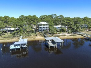 A waterfront property with multiple docks and a large house surrounded by trees. - "Bayside Retreat" Panacea FL...Bay Front, Dock, 2 Large Porches, No Pets, Wifi (Panacea)