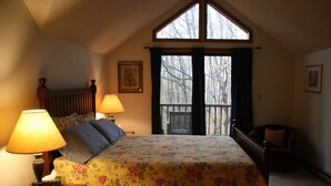 Un dormitorio con una cama, dos lámparas de noche, una ventana y una silla.