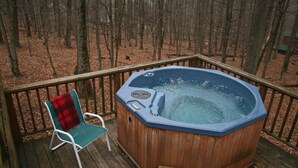 Una terraza de madera con un jacuzzi y una silla.