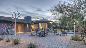 A patio with outdoor furniture, a grill, and a swimming pool.