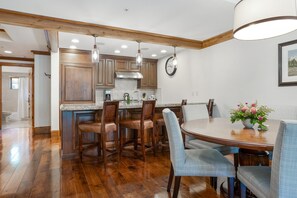 A kitchen with wooden cabinets, a central island, and bar stools.