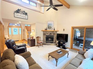A spacious living room with a fireplace, comfortable seating, and a television. - Serenity - Access to Swimming & Fishing Pond (Davis)