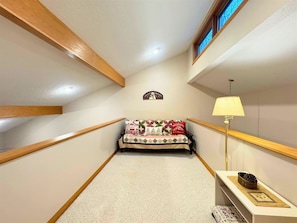 A small, cozy room with a bed, a lamp, and a wall-mounted decoration. - Serenity - Access to Swimming & Fishing Pond (Davis)