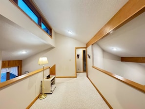 A narrow hallway with a lamp, a small table, and a door leading to another room. - Serenity - Access to Swimming & Fishing Pond (Davis)