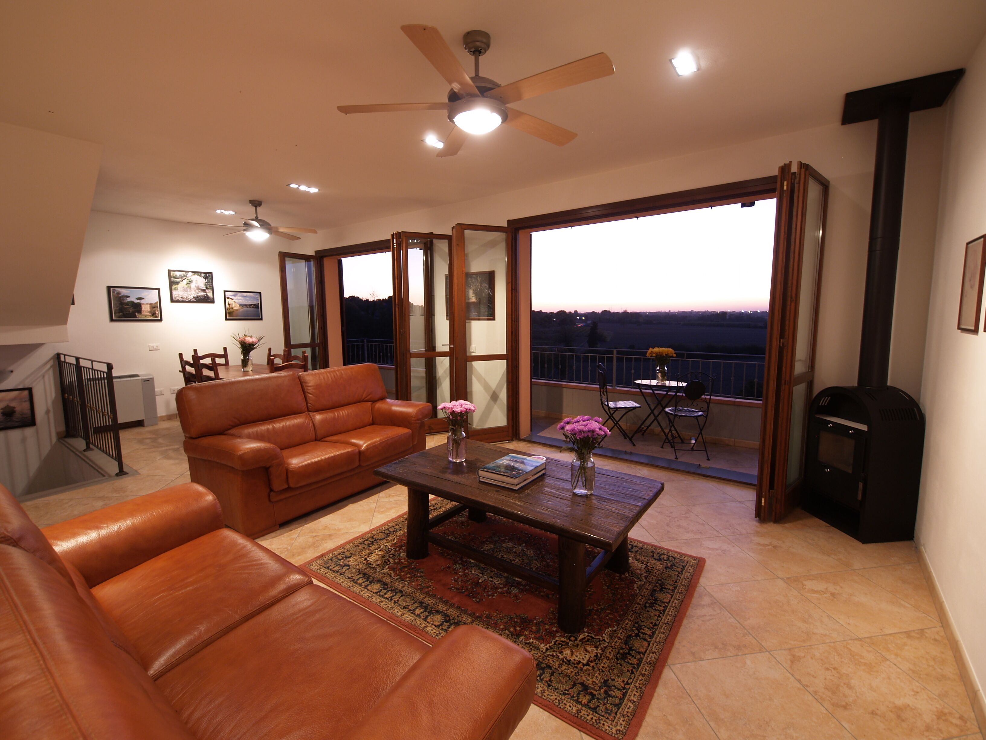 A spacious living room with a leather sofa, a coffee table, and a fireplace.