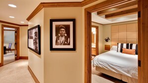 Hotelkamer met een groot bed, een hoofdbord, een ingelijste foto aan de muur en een houten plafond.