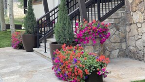 A multi-story building with a stone facade, a covered porch, and a staircase with black railings. - Riva Ridge Premium 745 | 2BR Vail Village (Vail)
