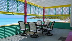 A covered outdoor seating area with a view of the ocean. - Secluded beach house on Hooper's Bay, Great Exuma, The Bahamas (George Town)
