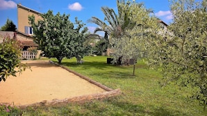 A sunny outdoor area with a sandy path, green grass, and various trees. - Beaucaire Avignon, Camargue  (Beaucaire)